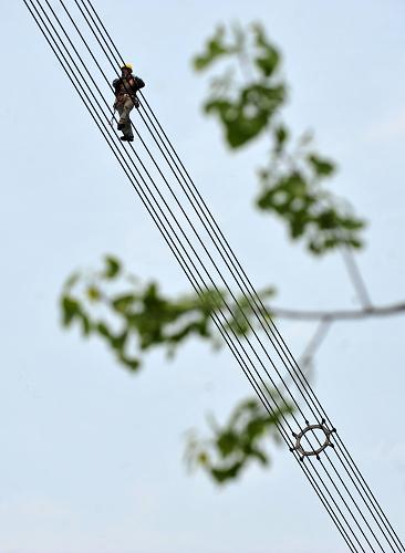 湖北超高压输变电公司的工人在特高压输电线上进行线路巡查(4月15日摄)。新华社记者 郝同前 摄