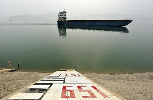 5月9日,一艘货轮从三峡水库上游太平溪水文标识前驶过。当日18时,三峡水库水位已降至154.77米。从7日开始,按长江防总要求,三峡水库紧急启动了抗旱应急调度,水库每秒的下泄流量一直维持在7000立方米左右,比长江上游来水要高出1500立方米。据了解,这是三峡水库成库以来第二次启动紧急调度。目前,三峡大坝所在的湖北省正遭遇50年罕见冬春连旱。新华社发(郑家裕 摄)
