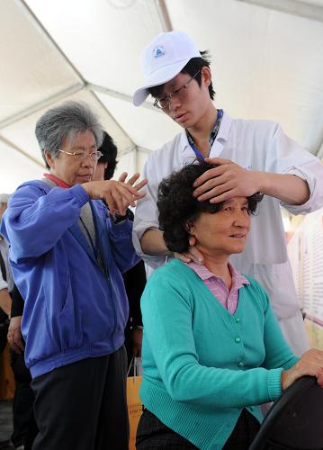 5月13日,一位市民(右)在体验中医按摩。新华社记者 李文 摄