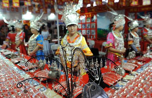 6月6日,一些来自贵州的少数民族姑娘穿着民族服饰推销银饰品。新华社记者 蔺以光 摄