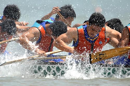6月5日,以“龙腾滨海,欢乐东疆”为主题的第二届天津港湾旅游文化节开幕式暨第四届中国大学生龙舟锦标赛在天津东疆海滩举行,一支参赛龙舟代表队的选手奋力划桨争先。新华社发(张颖 摄)