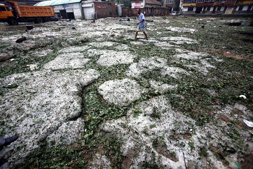 6月25日,河南嵩县县城一处地势低洼的停车场内落满厚厚的一层冰雹。新华社发(张晓理 摄)