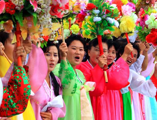 8月4日,在朝鲜元山,当地群众身穿民族盛装、手举鲜花,在码头欢迎中国海军训练舰编队。新华社记者查春明摄