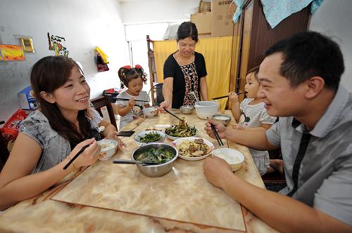 9月29日,外来工周晓君(右一)一家在廉租住房里用餐。2010年初,来自四川省大竹县川主乡的周晓君一家五口住进了晋江市深沪镇外来职工廉租住房小区,从此告别了高价租住的生活。 近年来,福建省晋江市加快外来职工廉租住房的建设步伐。从2009年起,晋江市在务工人员相对密集的深沪镇、晋江经济开发区五里园、陈埭镇、新塘街道等地,启动了5个外来职工廉租住房项目,在建总建筑面积26.34万平方米,总投资5.5亿元,可提供廉租住房4575套。截至目前,这5个项目的廉租房中有1400多套已封顶,200多套交付使用,其余的将在两年内陆续交付使用。晋江市是福建省民营经济发达地区,目前在这里的外来务工人员已超过100万人。新华社记者 张国俊 摄