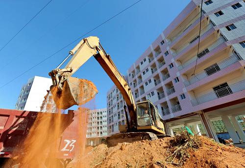 9月29日,一架挖掘机在福建省晋江市深沪镇外来职工廉租住房小区二期工程工地施工。新华社记者 张国俊 摄