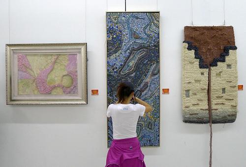 10月19日,参观者在中国美术学院美术馆欣赏工业设计类作品《流·行·色》。 当日,浙江省第三届大学生艺术展演活动美术作品展在杭州中国美术学院美术馆开展,展出了浙江68所高校师生创作的绘画、书法、摄影、工艺设计等门类的作品近800件,充分显示了当代大学生的精神风貌和艺术才华。新华社发(施健学 摄)