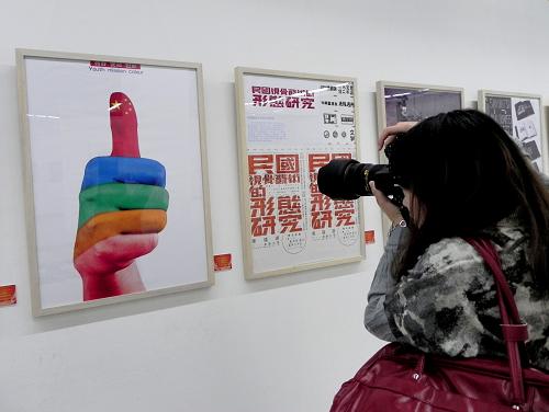 10月19日,参观者在中国美术学院美术馆拍摄公益广告画《青春·使命·色彩》。新华社发(龙巍 摄)