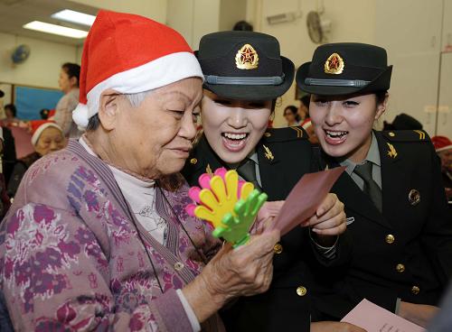 12月19日,驻港部队官兵代表与老人一起看着歌词唱歌。当日,中国人民解放军驻香港部队官兵代表前往仁济医院华懋护理安老院慰问老人,与他们共迎圣诞佳节。据悉,这是官兵们自2006年中秋节以来第6次组织此类活动,以此表达他们对香港老人的一份问候和关心。新华社记者 赵宇思 摄