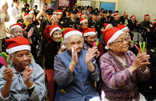 12月19日,驻港部队官兵代表与老年朋友们在一起联欢。新华社记者 赵宇思 摄