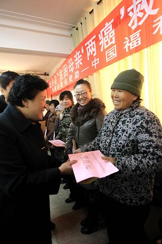 1月17日,甘肃省妇联副主席朱玉兰(左)在为一位“贫困母亲”发放“贫困母亲两癌救助专项基金”。新华社记者 李明放 摄
