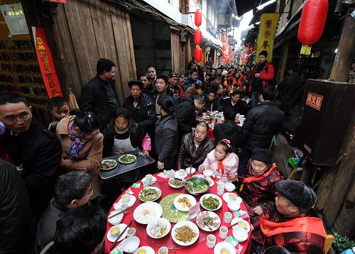 1月21日,中山古镇当地居民同享“千米长宴”,共迎新春。当日,“第七届江津中山古镇‘千米长宴’民俗民生文化活动”在重庆江津中山古镇开幕,活动包括为长寿老人拜寿、祭祀祈福、千米长宴、龙灯花灯拜年、送春联等内容。“千米长宴”是中山古镇的传统民俗,每年春节期间,古镇老街居民在千米古街上摆百家宴,共庆生意兴隆、家业兴旺,共祝风调雨顺、五谷丰登。新华社记者 李健 摄
