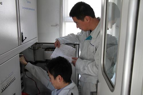 1月23日,在土库曼斯坦首都阿什哈巴德,中国南车青岛四方机车车辆股份有限公司驻阿什哈巴德的两名员工栾保峰(右)和滕纯岳处理车厢的配电柜故障。当日是中国农历大年初一,中国南车青岛四方机车车辆股份有限公司驻土库曼斯坦阿什哈巴德售后服务小组的工作人员们却没有休息,他们仍然坚守在工作岗位上,为中国列车保驾护航。中国南车四方股份公司是我国轨道交通装备制造业的领先企业,近年来积极拓展海外市场,至今已向数十个国家和地区出口产品。新华社记者 卢敬利 摄
