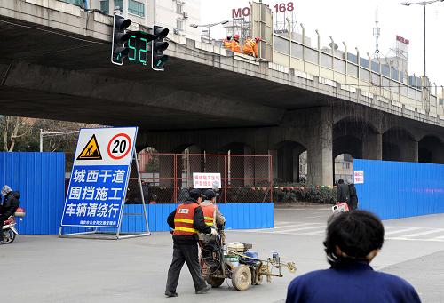 2月25日,正在进行爆破拆除准备工程的水西门高架桥下,施工围挡外的路口设立了车辆绕行提示牌。新华社记者 孙参 摄