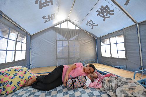 9月14日,产下男婴刚两天的冯明英在彝良县妇联设立的“产妇帐篷”内哄婴儿入睡。新华社记者 李鑫 摄