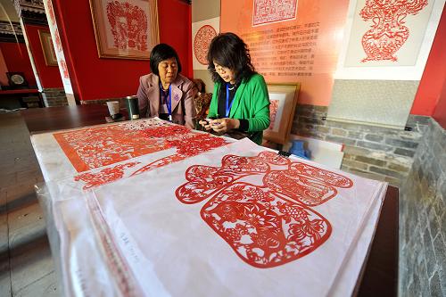 9月19日,在中国山西非物质文化遗产博览会上,民间艺人在现场制作中阳剪纸。新华社记者 詹彦 摄