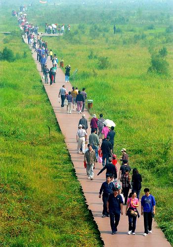 10月2日,游客们在郑州黄河湿地公园内游玩。“双节”期间,在郑州黄河湿地公园举办的首届黄河湿地文化节受到了郑州市民和游客的欢迎。“保护黄河湿地万人签名活动”“黄河湿地生态游”“黄河湿地观鸟节”等活动让人们在亲近黄河湿地的同时享受到现代文明和生态文明融为一体的独特魅力。 郑州黄河湿地是我国河流湿地生物多样性最为丰富的地区之一,也是我国候鸟迁徙的重要通道。新华社记者 王颂 摄