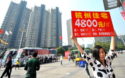 10月20日,一名房产推销人员正在浙江省房博会会场外推销一处杭州远郊低价楼盘。新华社记者 王定昶 摄