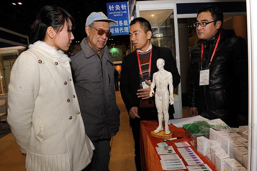 12月6日,来宾在参展商的帮助下了解针灸针的使用。当日,由中华中医药学会、北京中医药学会等单位联合举办的“第二届中国中医药文化与产业博览会”在北京展览馆举行。博览会旨在弘扬中医药文化、激发中医药文化创新、提高中医药健康服务水平,促进国内外传统医药界在学术领域的交流与合作。博览会除承袭上届百年品牌老店中医药文化展示,还新增了中药保健产品特别是中医膏方中药膏滋的展览,并突出首都地产中药材和全国道地中药材文化的交流与推广。博览会开辟了“中医专家保健咨询区”,为来宾免费提供专业的中医药诊疗健康咨询服务及养生保健讲座。新华社记者 何俊昌 摄