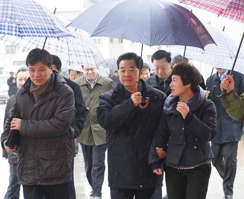 12月26日至29日,国家主席胡锦涛在江苏考察工作。这是胡锦涛在盐城市恒北村考察时为讲解的村支书打伞。新华社记者 李学仁 摄