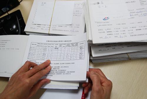 1月22日,上海市长宁区周家桥街道社区卫生服务中心的家庭医生陈华在整理社区居民的健康状况管理卡片。新华社发(丁汀 摄)