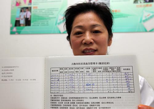 1月22日,上海市长宁区周家桥街道社区卫生服务中心的家庭医生陈华在展示她为社区高血压病人进行健康管理的记录卡。新华社发(丁汀 摄)