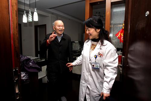 1月22日,上海市长宁区周家桥街道社区卫生服务中心的家庭医生方红为社区居民徐文乐“上门服务”,对他的慢性病进行病情监测,临走时老人送她到门口。新华社发(丁汀 摄)
