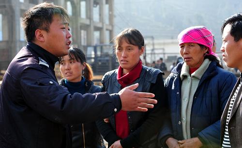 1月23日,一名工作人员在安抚遇难矿工的亲友。新华社记者 杨楹 摄