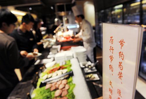 1月24日,顾客在青岛海景花园大酒店自助餐厅取餐。新华社记者 李紫恒 摄