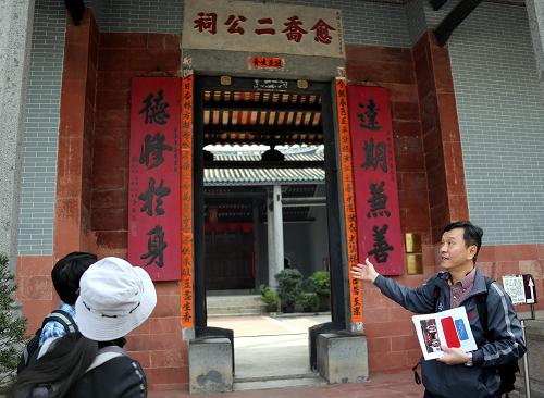 1月26日,香港孔子学院院长朱鸿林教授(右)在香港元朗屏山文物径愈乔二公祠为考察团成员讲解。新华社记者李鹏摄