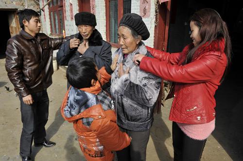 1月29日,回到家中的陈顺付和妻子一起帮老人试穿为他们购买的过年穿的新装。