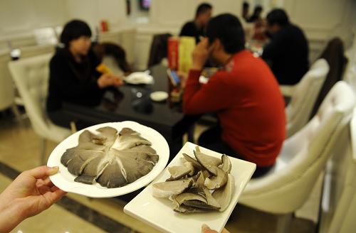 在宁夏银川一火锅店内,服务员端着整份和半份平菇上菜(2月16日摄)。新华社发(李然 摄)