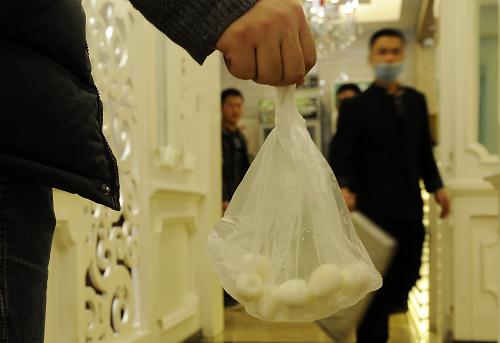 在宁夏银川一火锅店内,一顾客将没吃完的涮品打包带走(2月16日摄)。新华社发(李然 摄)