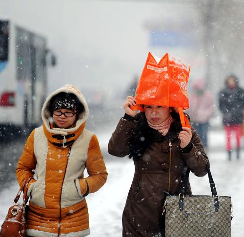 3月21日,两位市民在哈尔滨街头冒雪前行。当日,黑龙江省部分地区迎来降雪天气。据气象部门预报,3月21日下午至22日白天,降雪范围将由黑龙江省西南部地区向中东部地区扩展。新华社记者 王松 摄