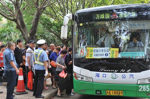 4月4日,在海口市滨海大道紫荆路口,市民准备乘坐开往颜春岭安乐园的免费公交。4月3日至5日,海口市交通部门提供公交保障,方便市民前往颜春岭、富山、吉萌贤等公墓园区祭扫。当日是清明节,海口市气温达32摄氏度,不少市民冒着高温、撑着遮阳伞来到海口最大的陵园——颜春岭安乐园进行祭扫。有媒体预计4月4日园区扫墓人数达10万人次。新华社记者 施鳗珂 摄