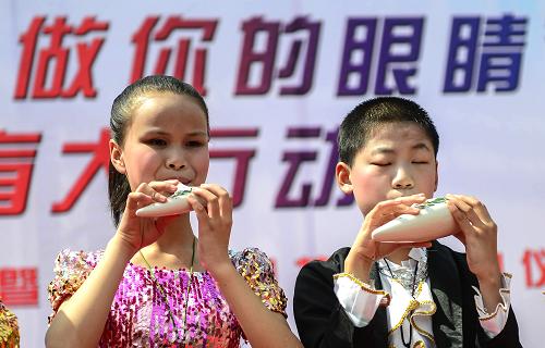 4月12日,武汉市盲童学校的学生在公益活动启动仪式上用音乐表达感受。新华社记者 程敏摄
