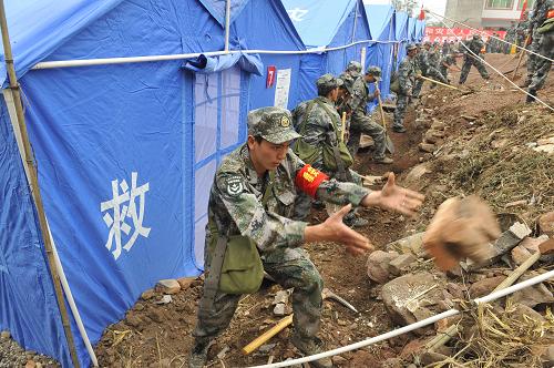 4月28日,在四川芦山县龙门乡古城村受灾群众安置点,救援官兵在挖掘排水沟渠。新华社记者 鲁鹏 摄