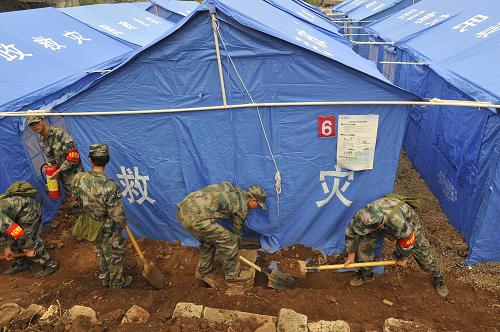 4月28日,在四川芦山县龙门乡古城村受灾群众安置点,救援官兵在挖掘排水沟渠。新华社记者 鲁鹏 摄