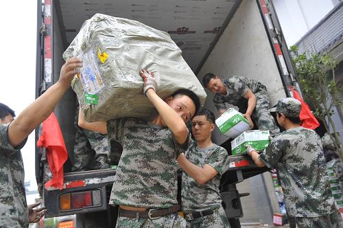 4月28日,雅安陆军预备役步兵团的官兵在芦山县龙门乡青龙场村救灾物资转运点搬运救灾物资。新华社记者 鲁鹏 摄