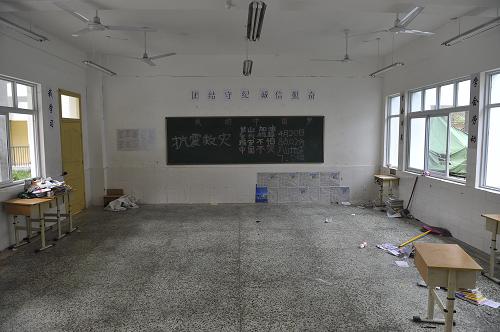 这是5月2日拍摄的宝兴县中学七年级(3)班教室。在灾后初期搭建救灾帐篷时,由于物资短缺,学校教室里的许多课桌椅被拿到安置点供受灾群众使用。新华社记者 鲁鹏 摄