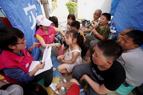 5月3日,志愿者在芦山县临时搭建的“儿童欢乐驿站”教当地儿童学习知识。四川芦山“4·20”强烈地震发生后,中国妇女发展基金会携手中国科学院心理研究所在灾区设立“妇女儿童服务站”,有针对性地帮助当地困难妇女,舒缓她们焦急、烦躁、困惑等心理压力,并特别设立“儿童欢乐驿站”,通过各种方式抚慰儿童的紧张不安情绪。新华社记者 李明放 摄