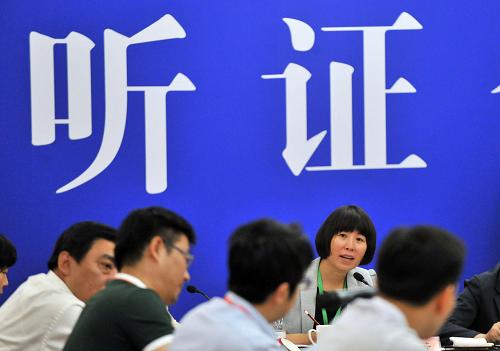5月23日,北京市发展和改革委委员、听证会主持人李素芳与听证会参加人交流。新华社记者 李文 摄