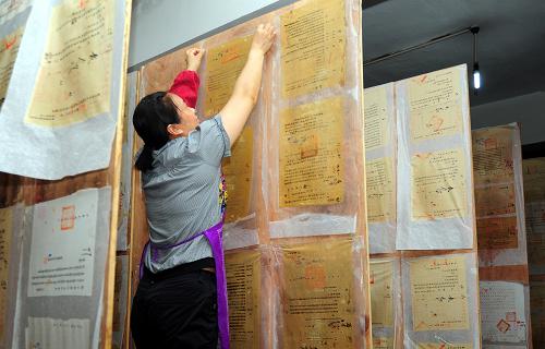 6月23日,四川省邻水县档案馆的工作人员将修裱后的国家重点档案晾干。新华社发(邱海鹰 摄)