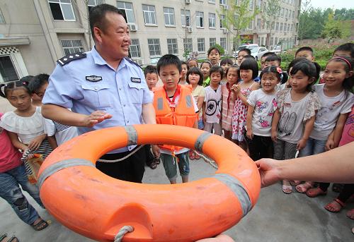 6月26日,山东省临沂市郯城县公安局北关派出所民警在东庄树华希望小学为小学生们讲解防溺水知识。暑假来临前夕,山东省临沂市郯城县供电、公安、交警等部门组织工作人员来到郯城县郯城街道东庄树华希望小学为学生讲解安全用电、防溺水以及交通安全等知识,确保孩子们平安度暑假。新华社发(张春雷 摄)