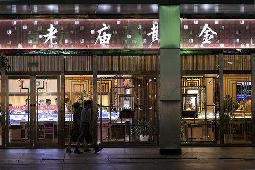 8月12日,行人从上海一家老庙黄金店铺门口走过。新华社发 (吴子熙 摄)