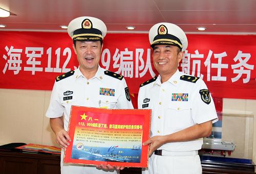 8月22日,在中国海军第十四批护航编队哈尔滨舰上,第十四批护航编队指挥员、北海舰队副司令员袁誉柏(右)和第十五批护航编队指挥员、南海舰队装备部部长姜中华展示签好的任务交接书。新华社记者 梁舜 摄