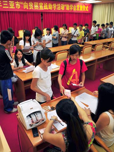 8月23日,在2013年三亚市“向贫困宣战助学活动”助学金发放仪式现场,学生在排队领取现金资助。新华社发(沙晓峰 摄)