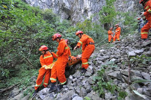 10月9日,消防战士在天门山一处峡谷内的碎石陡坡搬运遇难选手遗体。新华社记者 龙弘涛 摄
