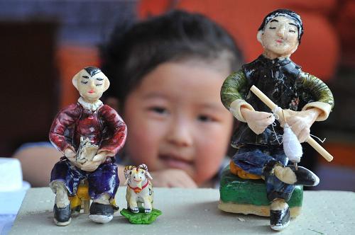 10月10日,一名小朋友在山西省新绛县“一村一品”展示交流会上观看面塑作品“留守儿童”。当日,为期5天的山西省新绛县第三届“一村一品”展示交流会开幕,来自全县各乡镇的“一村一品”特色农产品集体亮相。此次展交会共设展位1500多个,展品包括蔬菜、水果、粮食、中药材等3000多个品种,吸引了众多农民、客商前来参观、洽谈。新华社发(高新生 摄)