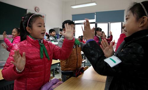 12月5日,上海中心气象台发布今年入冬以来首个大雾橙色预警,在上海金山区海棠小学二(7)班,学生们在老师的带领下,做室内课间操,消除疲劳,锻炼身体。新华社发(庄毅 摄)
