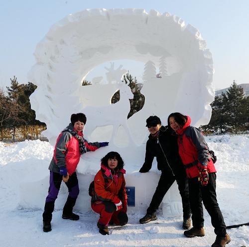 1月7日,几位游客在获得一等奖的哈尔滨工程大学的雪雕作品《动物博物馆》前合影。当日,以“灵动·雪之梦”为主题的2014年第六届国际大学生雪雕大赛在哈尔滨工程大学落下帷幕。来自中国、俄罗斯、英国、日本、朝鲜、泰国、马来西亚、丹麦、韩国等11个国家和地区的61支参赛队参赛。大学生们在4天的时间里用无限的创意、手中的铁铲、团队的合作同台切磋雪雕技艺、释放自己的青春能量和冰雪梦想。新华社记者 王松 摄